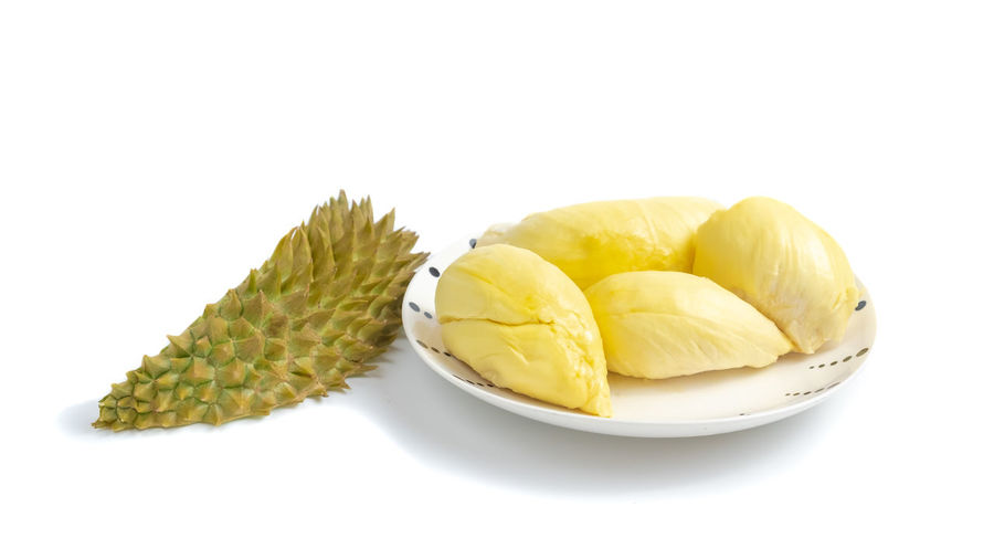 Close-up of fruits in plate against white background