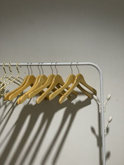 Close-up of empty clothes on rack against wall