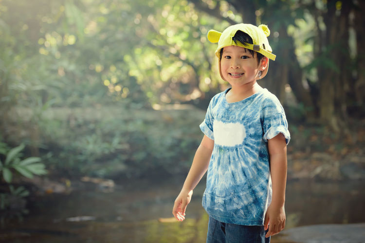 Cute smiling boy standing by stream