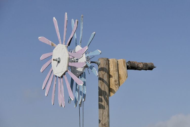 Low angle view of traditional windmill against clear blue sky