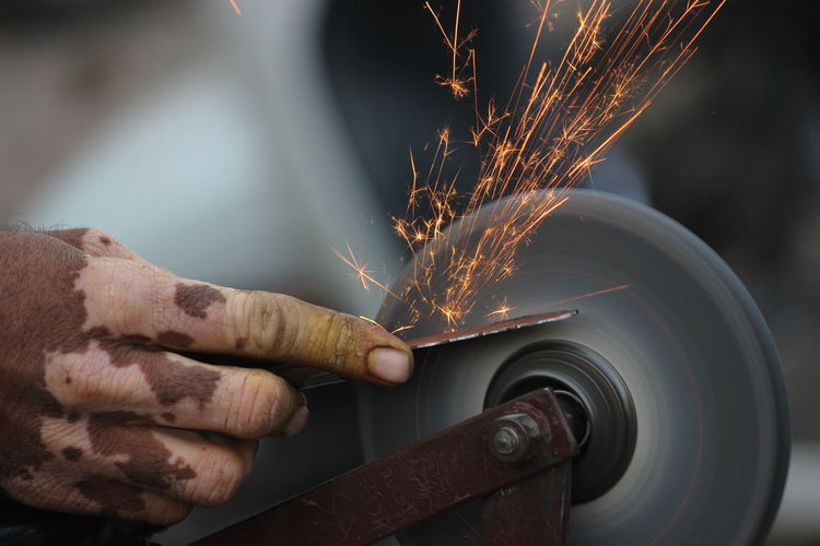 Close-up of hand working on metal