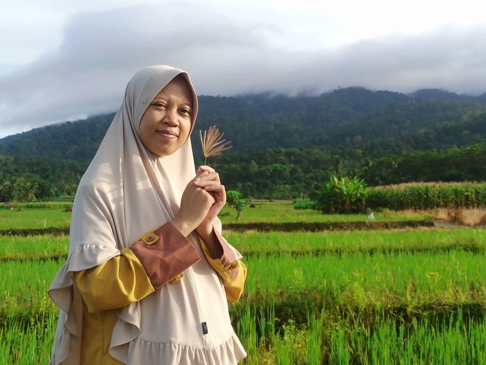 Smiling young woman standing on field