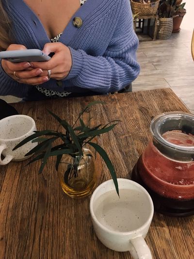 Midsection of man using smart phone on table