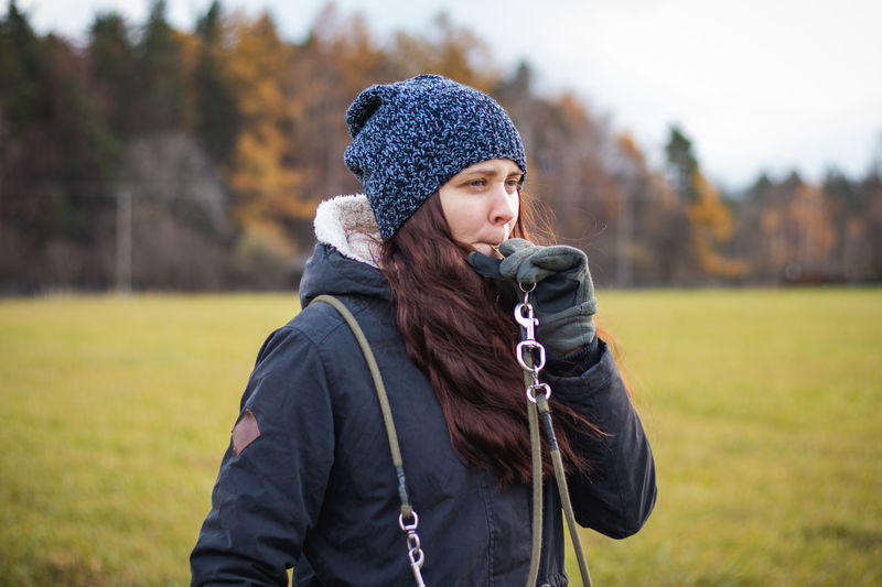 Young woman wearing hat standing on field