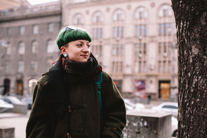 Portrait of happy hipster woman standing on street in city