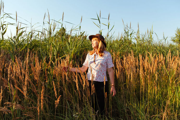 Young woman standing amidst wheat field