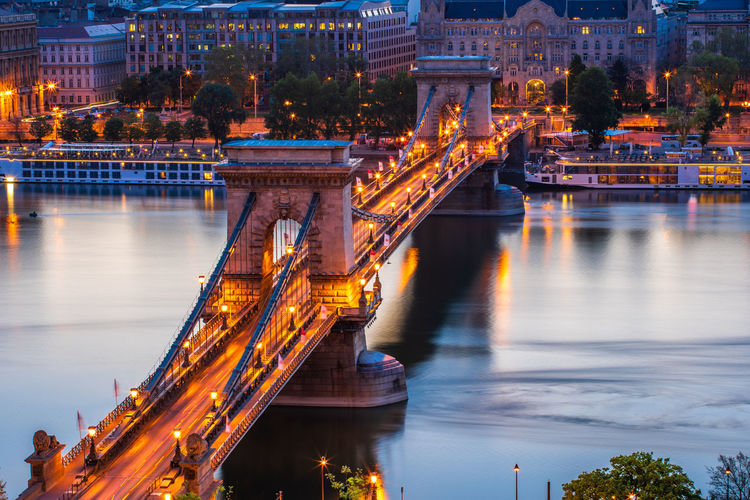 High angle view of illuminated bridge over river at dusk