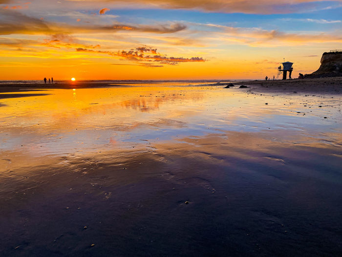 Warm sunset over reflective sand beach landscape
