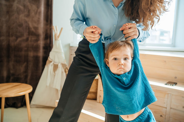 Mother with baby son on the background of a window and a wooden bench. high quality photo