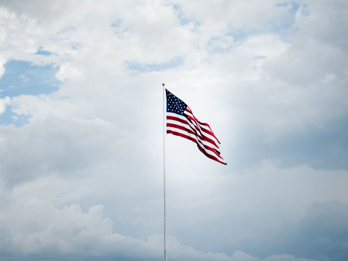 Low angle view of american flag against sky