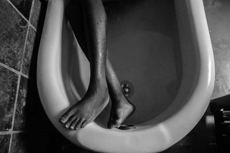 Low section of woman resting in bathtub