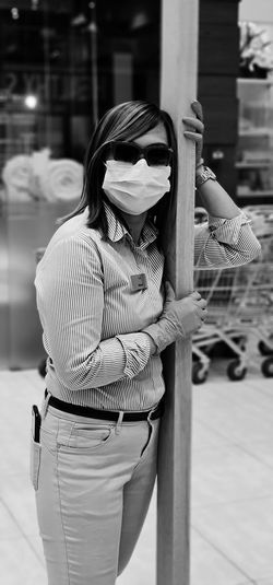 Portrait of woman wearing mask standing in shopping mall