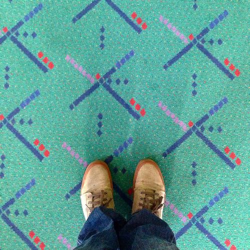 Low section of man standing on carpet at airport