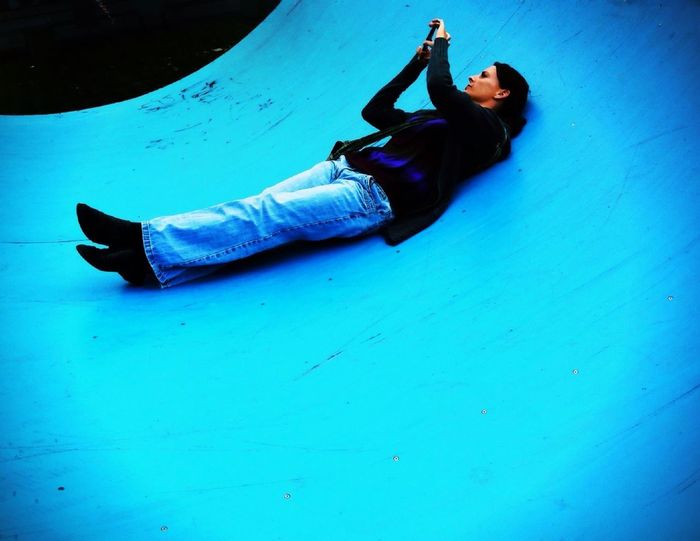 Woman lying on blue half pipe