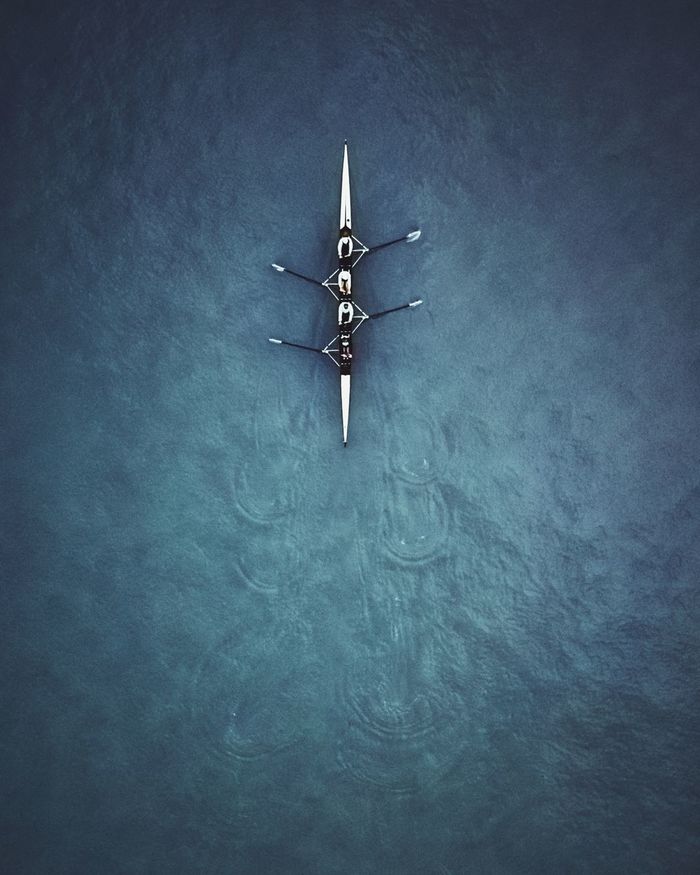 Aerial view of people rowing boat at sea