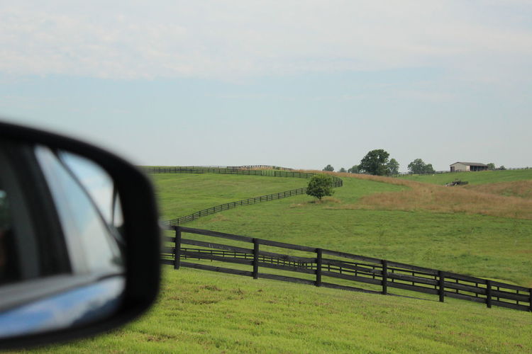 Scenic view of field seen through car windshield