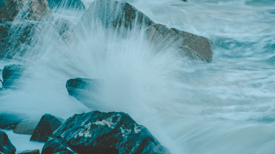 Close-up of sea wave splashing on rock