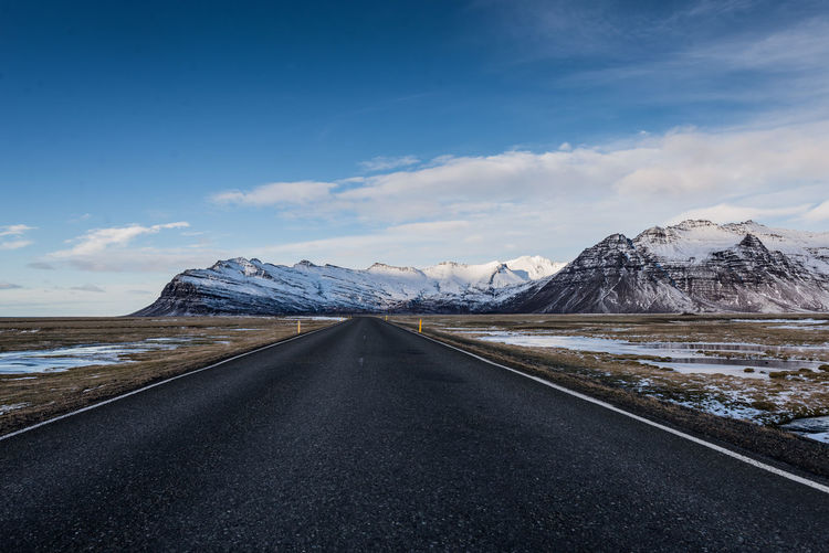 Road and snowcapped mountains against sky