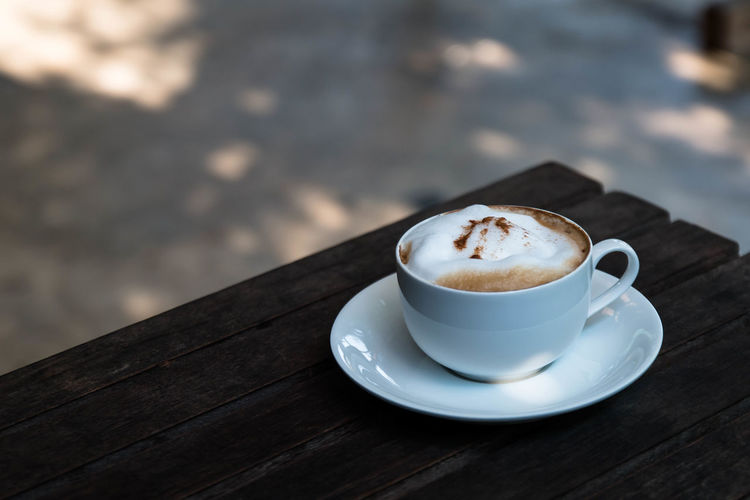 Close-up of coffee cup on wooden table