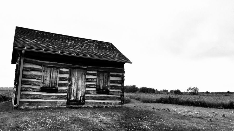 Abandoned house on field against sky