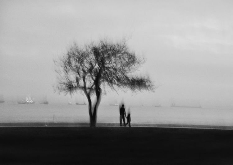 Silhouette of two people walking on road