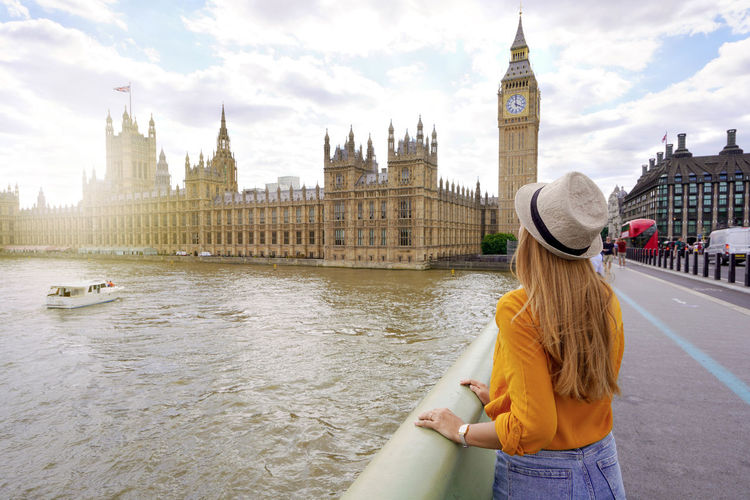 Traveler girl enjoying sight of westminster palace and bridge on thames with big ben tower in london