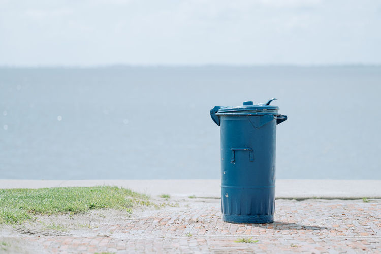 Blue garbage can on the seashore
