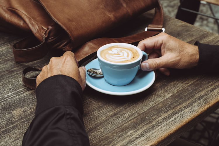 Cafe Cappuccino Coffee - Drink Coffee Culture Coffee Cup Food And Drink Froth Art Frothy Drink High Angle View Holding One Man Only One Person Real People Style Table
