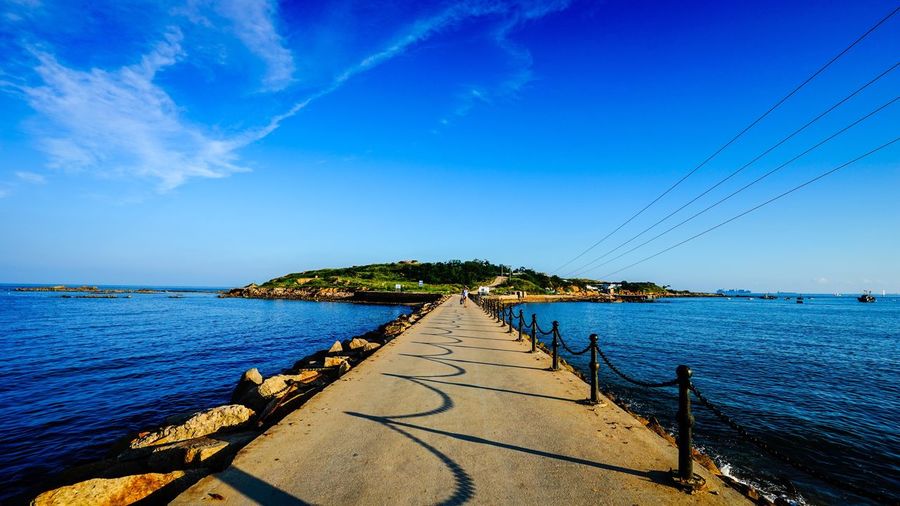 Empty jetty leading to calm sea