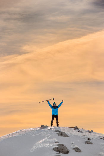 Full length of person standing in snow against sky during sunset