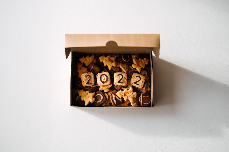 Diy christmas cookies with 2022 numbers, letters and christmas tree shapes in craft box. tasty