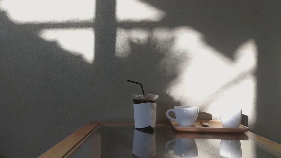 Coffee cup on table against wall at home