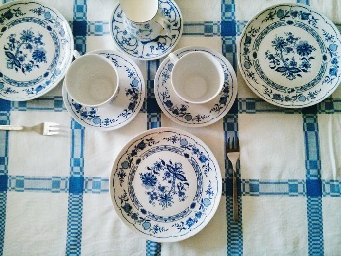 Directly above shot of plates and tea cups arranged on table