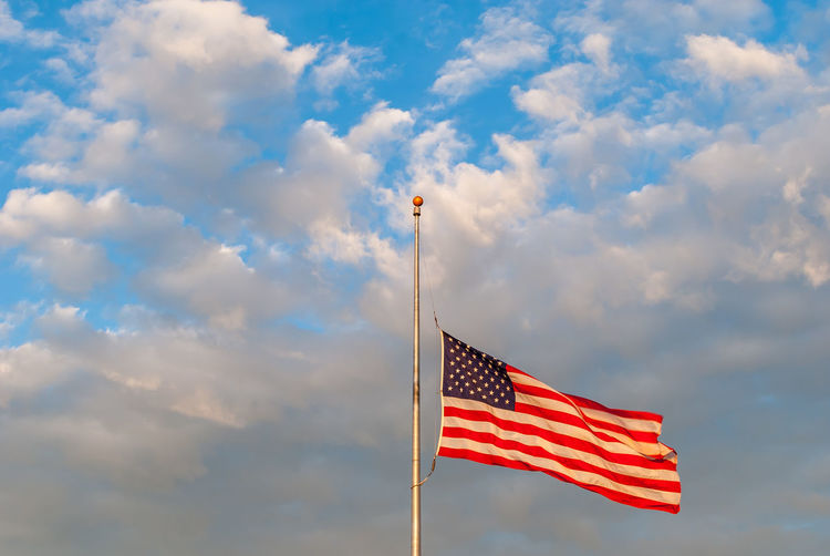 Low angle view of american flag against sky
