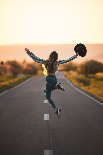 Full length of woman exercising on road