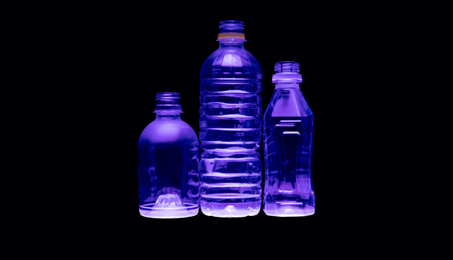 Close-up of empty glass bottle against black background