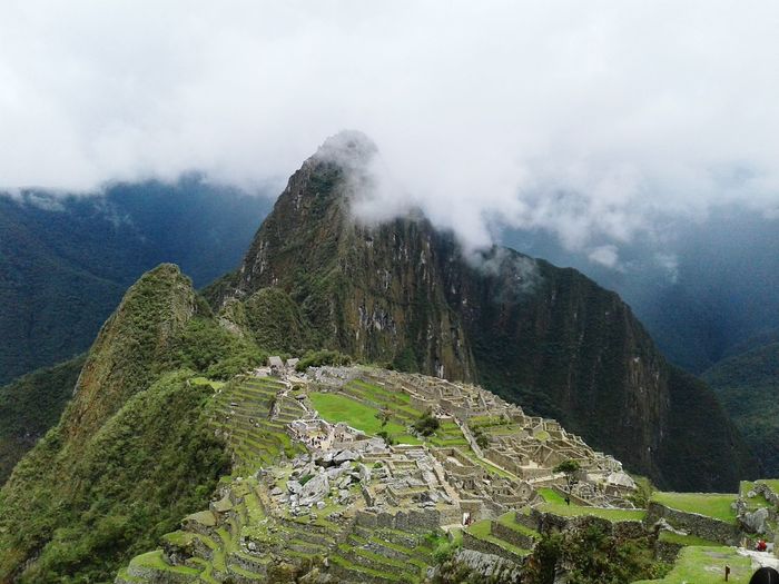 Aerial view of machu picchu by mountains against cloudy sky