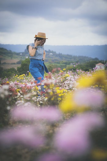 Beautiful woman standing in blooming flower garden