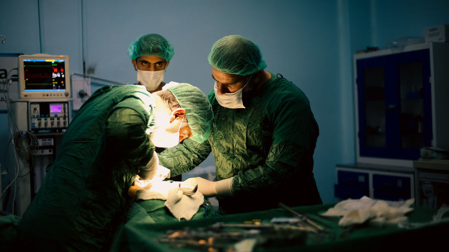 Medical team of surgeons in hospital doing minimal invasive surgical interventions. 