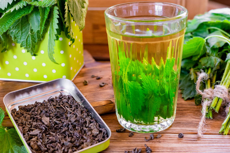 Healing herbal tea with nettle. tea in a glass on a wooden table. the source of vitamins 