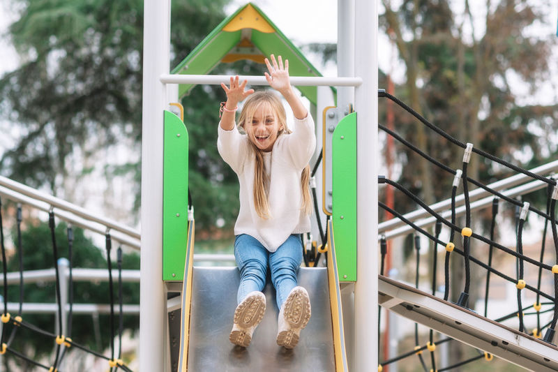 Portrait of girl sliding in playground