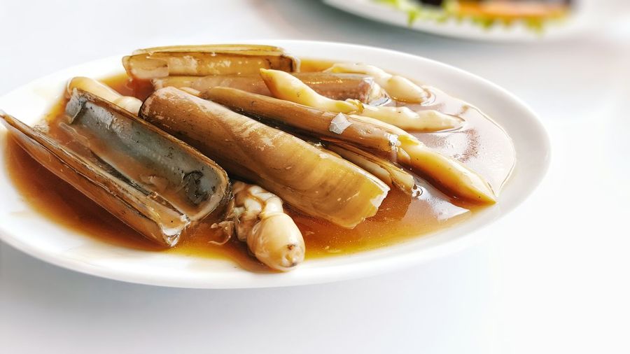 Close-up of pacific razor clam served in plate on table