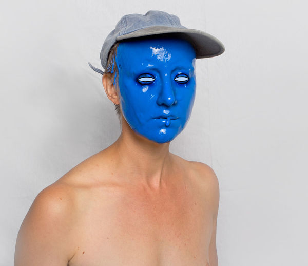 Portrait of shirtless man wearing mask against white background