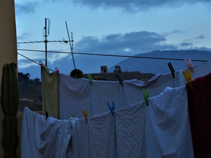 Clothes drying on clothesline against sky