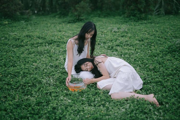Friends relaxing on field
