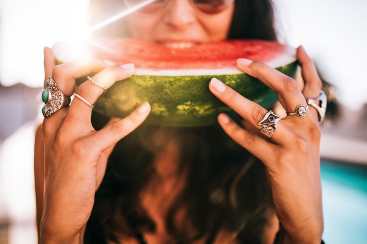 Midsection of woman eating watermelon