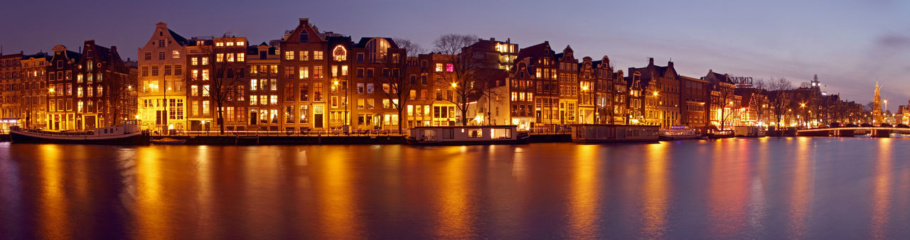 Illuminated buildings in city at waterfront