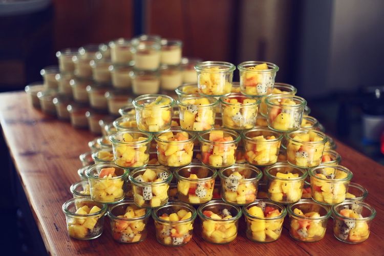 Chopped fruits in containers arranged on table