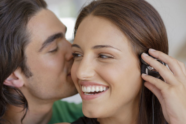 Close-up of man kissing smiling woman
