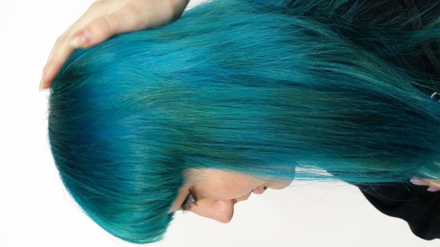 Side view of young woman with blue hair